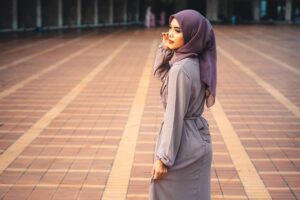 Portrait of a woman in stylish hijab standing at Istiqlal Mosque, Jakarta. Captures beauty and cultural grace.