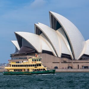 View of the Sydney Opera House with a ferry passing by in Sydney Harbour, Australia.